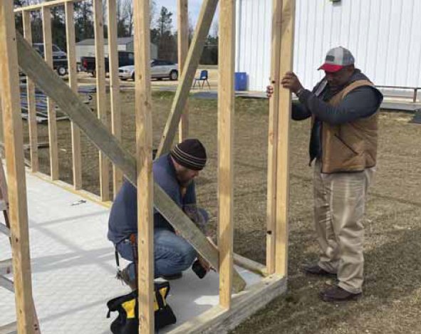 KCHS softball coach Freddy Thomas, left, and construction instructor George White work on new dugouts.